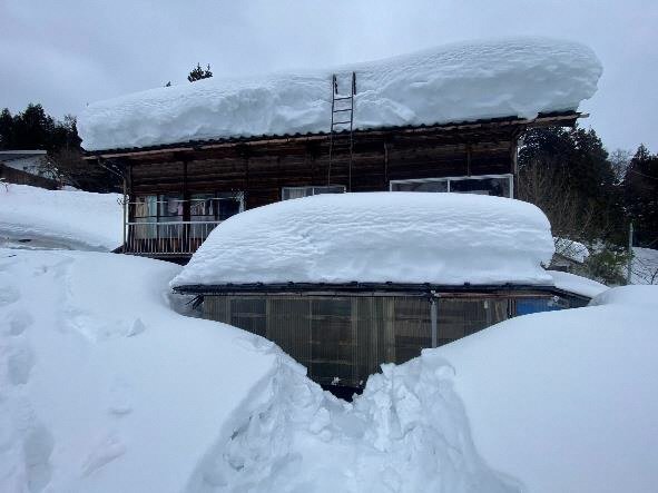 雪に埋もれた家の玄関先